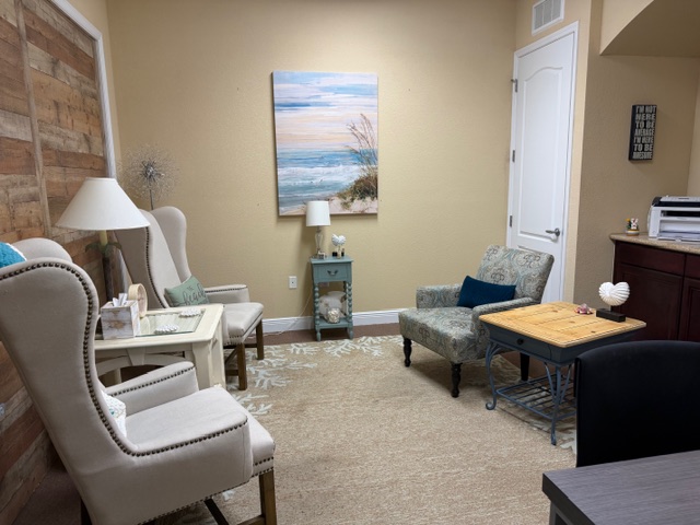 Coastal therapy room with ocean painting and reclaimed wood accent wall