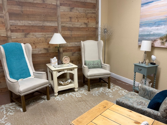 Wingback chairs with turquoise throw blanket and beach painting