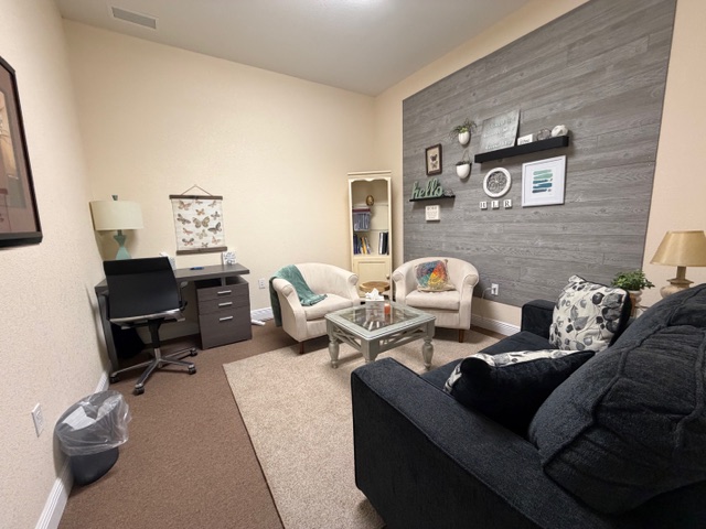 Modern therapy room with grey wood accent wall and plush seating