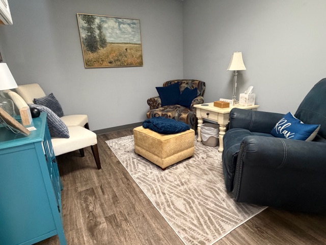 Therapy room with navy recliner and Relax pillow