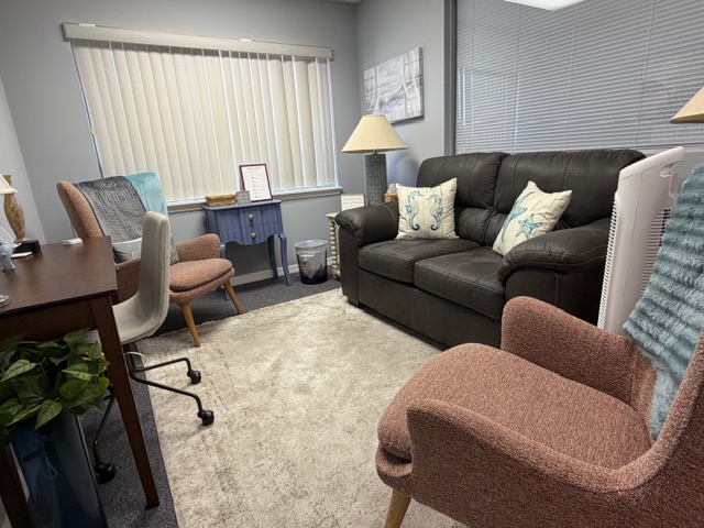 Spacious therapy room with leather sofa and warm lighting